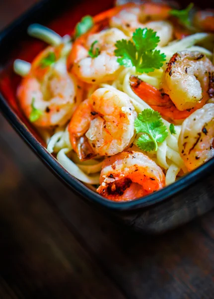 Pasta mit gegrillten Garnelen auf hölzernem Hintergrund — Stockfoto