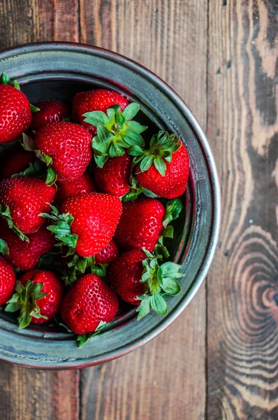 Strawberries in a bowl on wooden background — Stock Photo, Image