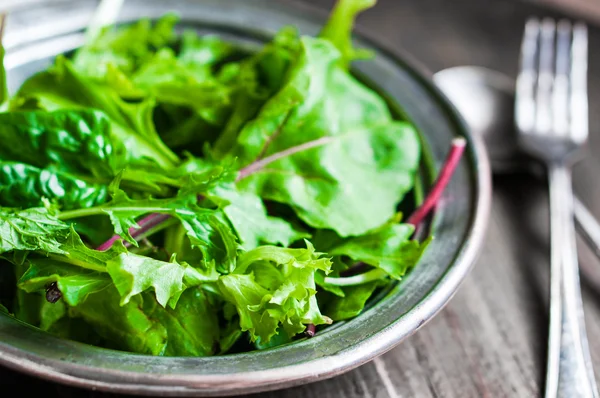 Green salad on rustic background — Stock Photo, Image
