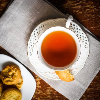 Ahşap zemin üzerinde kurabiyeler olan çay