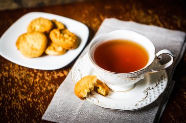 Ahşap zemin üzerinde kurabiyeler olan çay