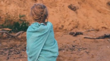 küçük kız oynar, suyun uzaktan görünüyor