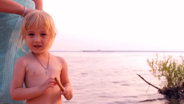 Mother braids, brushes the little girl on a beach — Stock Video