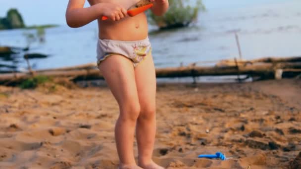 Niña juega, mira lejos al agua — Vídeos de Stock