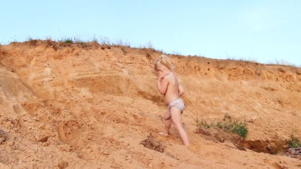 Pequena menina clambers na areia para cima, joga — Vídeo de Stock