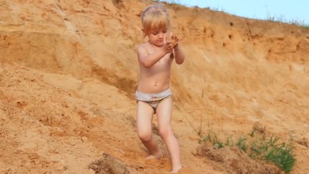 Kleines Mädchen klettert auf Sand hoch, spielt — Stockvideo