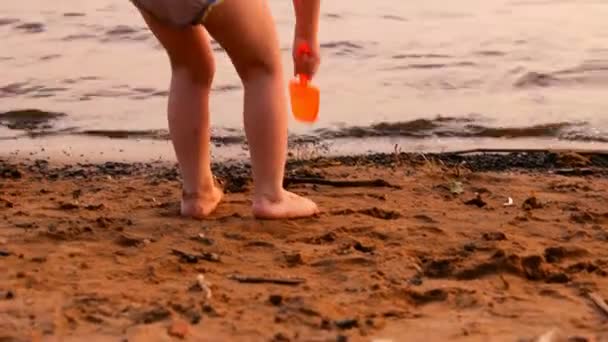 Küçük kız oynar, suyun uzaktan görünüyor — Stok video