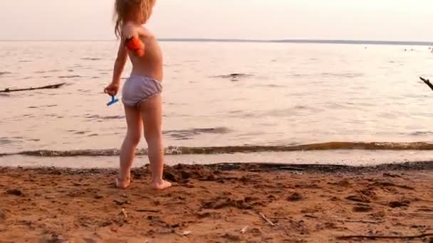 小さな女の子を果たしている, 水で遠くに見える — ストック動画