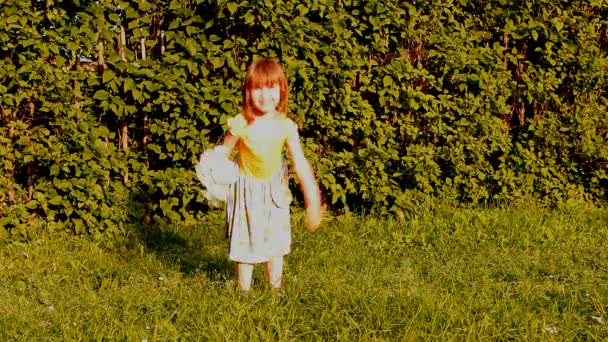 Petite fille avec un bouquet de camomilles saute, saute, court, rit — Video