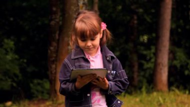 küçük kız bir tablet, laptop, netbook, ipad ile oynuyor