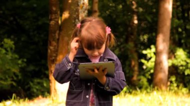 küçük kız bir tablet, laptop, netbook, ipad ile oynuyor