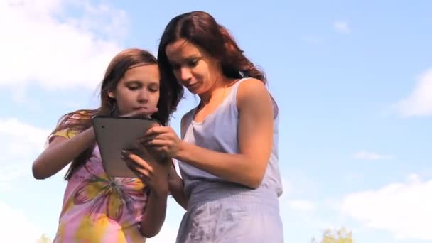 Två tjejer spela arbete med en tablett, ipad, den bärbara datorn — Stockvideo