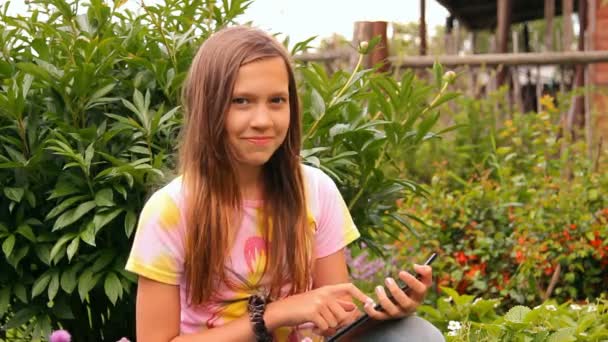 A menina, o adolescente brinca, trabalha com um tablet, iPad — Vídeo de Stock