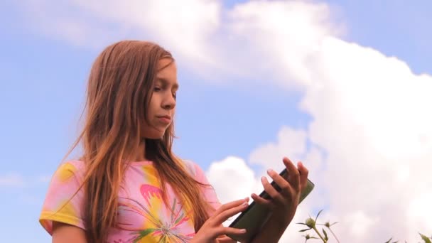 A lány, a tinédzser játszik, szerkezet-val egy tabletta, ipad — Stock videók