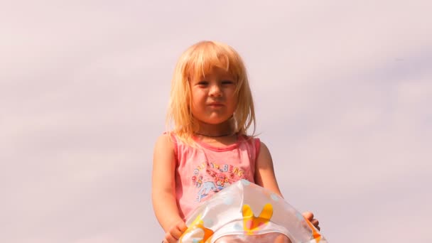 The little girl swings an inflatable mattress for swimming — Stock Video