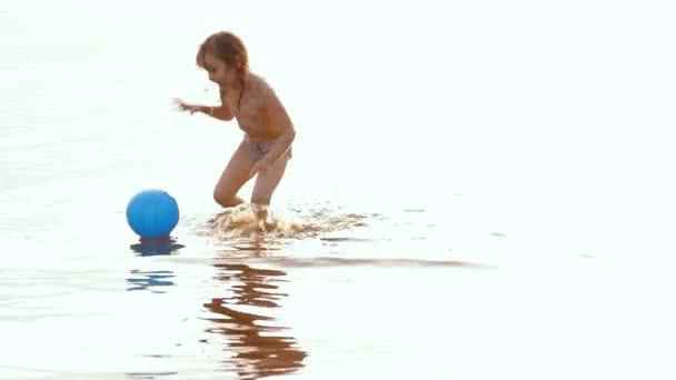 La niña va a bañarse, a flotar con una pelota — Vídeo de stock