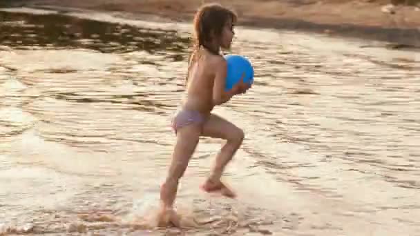 La niña va a bañarse, a flotar con una pelota — Vídeo de stock