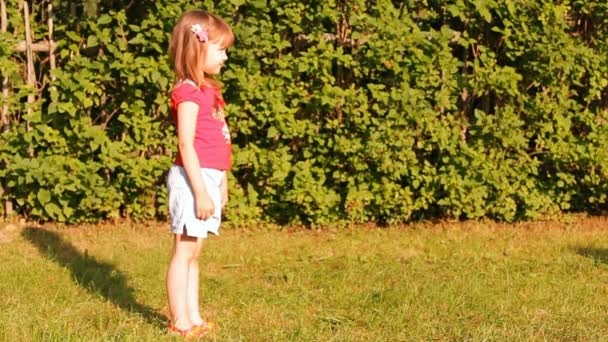 A menina joga uma bola ao ar livre — Vídeo de Stock