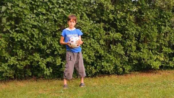 De jongen speelt een bal buiten — Stockvideo