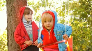 oynarken, salıncakta gülüyor iki kız