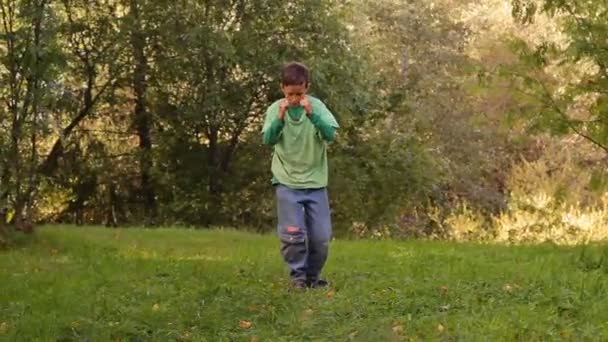 Хлопчик танцює бульбашкою дві дівчини біжать до нього — стокове відео