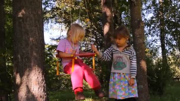 Oynarken, salıncakta gülüyor iki kız — Stok video