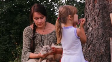 bir anne ile iki çocuk ve bir kedi konuşuyor, gülüyor