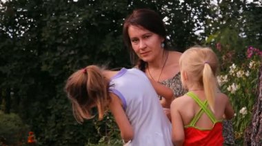 bir anne ile iki çocuk ve bir kedi konuşuyor, gülüyor