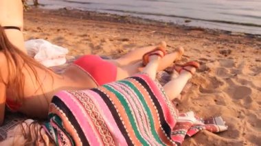 kız kardeşi yanındaki sahilde bir battaniye koyar.