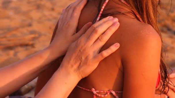 La mère et une fille sur la plage, une femme fait un massage — Video