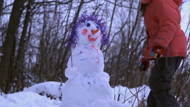 Ein kleines Mädchen spielen mit Schneemann — 图库视频影像