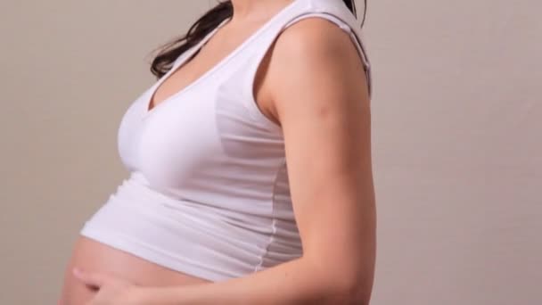 Une femme enceinte caressant l'abdomen, yoga — Video