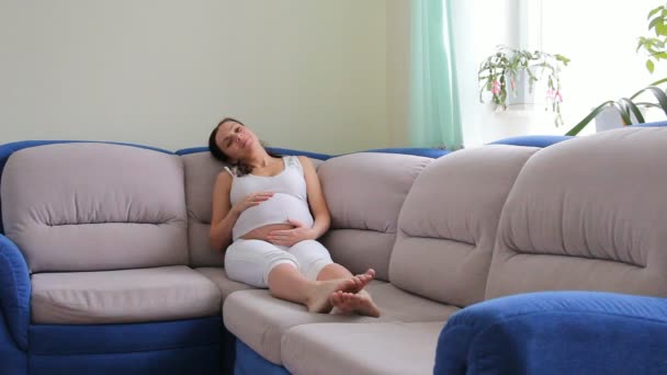 Mujer embarazada con ropa blanca toca el vientre — Vídeos de Stock