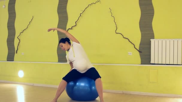 Una donna incinta che fa esercizi con la palla, yoga — Video Stock