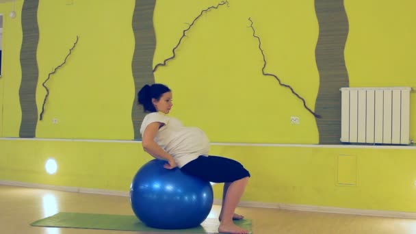 Hamile bir kadın ile topu, yoga egzersizleri yapıyor — Stok video