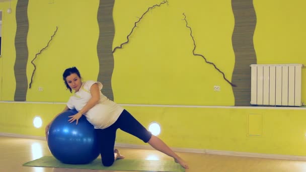 En gravid kvinna gör övningar med bollen, yoga — Stockvideo