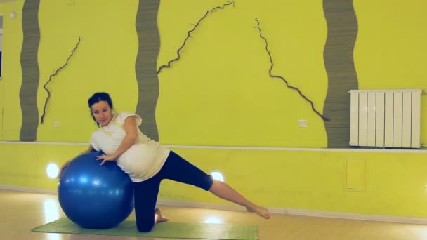 En gravid kvinna gör övningar med bollen, yoga — Stockvideo