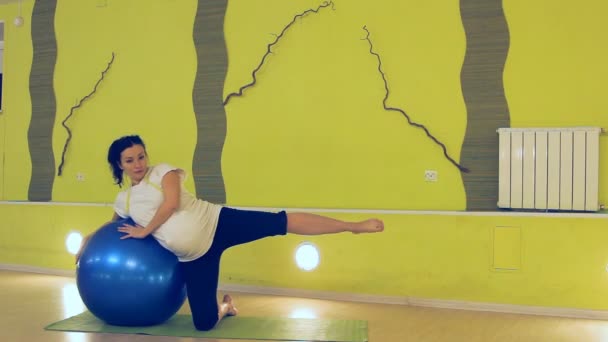 Hamile bir kadın ile topu, yoga egzersizleri yapıyor — Stok video