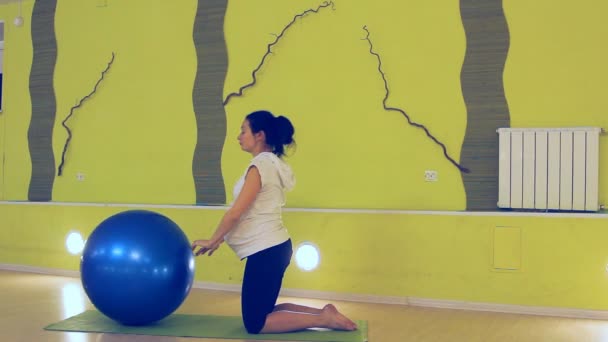 Een zwangere vrouw doen oefeningen met de bal, yoga — Stockvideo