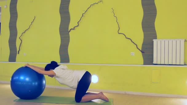 Беременная женщина делает упражнения с мячом, йогой — стоковое видео