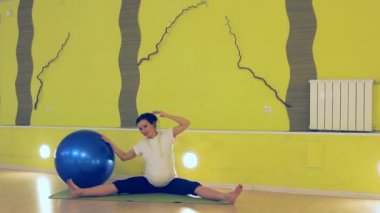 hamile bir kadın ile topu, yoga egzersizleri yapıyor