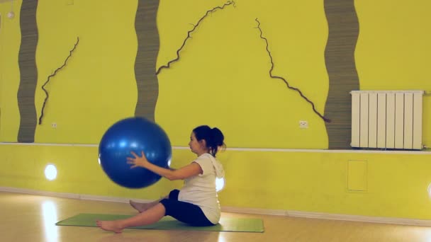 Een zwangere vrouw doen oefeningen met de bal, yoga — Stockvideo