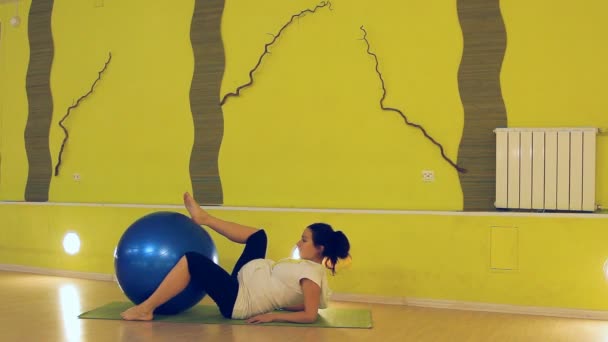 En gravid kvinna gör övningar med bollen, yoga — Stockvideo