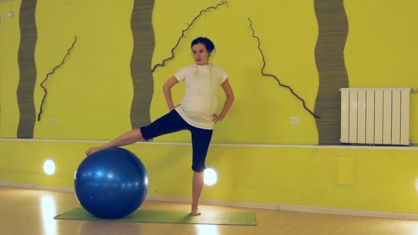 Вагітна жінка робить вправи з м'ячем, йога — стокове відео