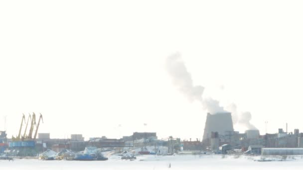 スキーヤーは工場の煙突および煙の背景に対して行く — ストック動画