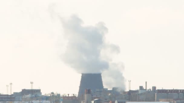 スキーヤーは工場の煙突および煙の背景に対して行く — ストック動画