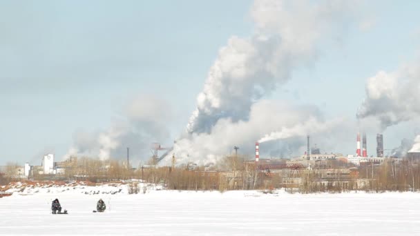 Зимова риболовля на тлі заводських димоходів, кранів — стокове відео