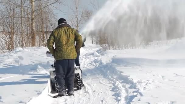 Mannen shoveling sneeuw machine en schop — Stockvideo