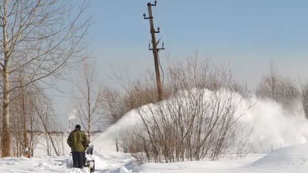 Mannen shoveling sneeuw machine en schop — Stockvideo