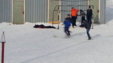 Kışın futbol oynayan gençler